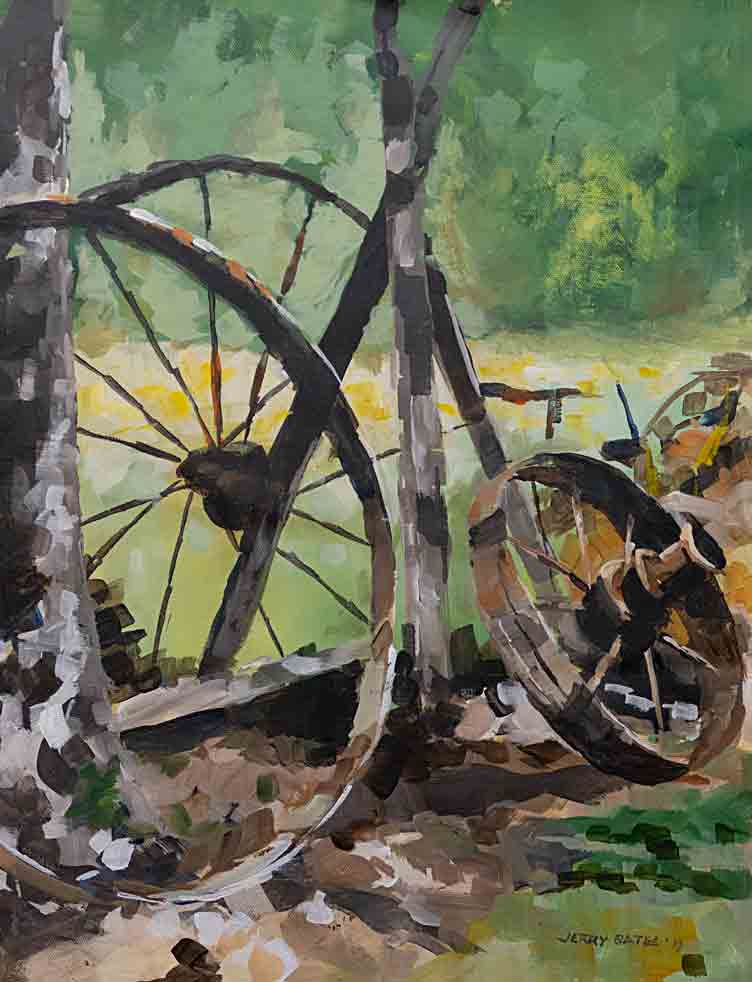 old wheels leaning agains tree